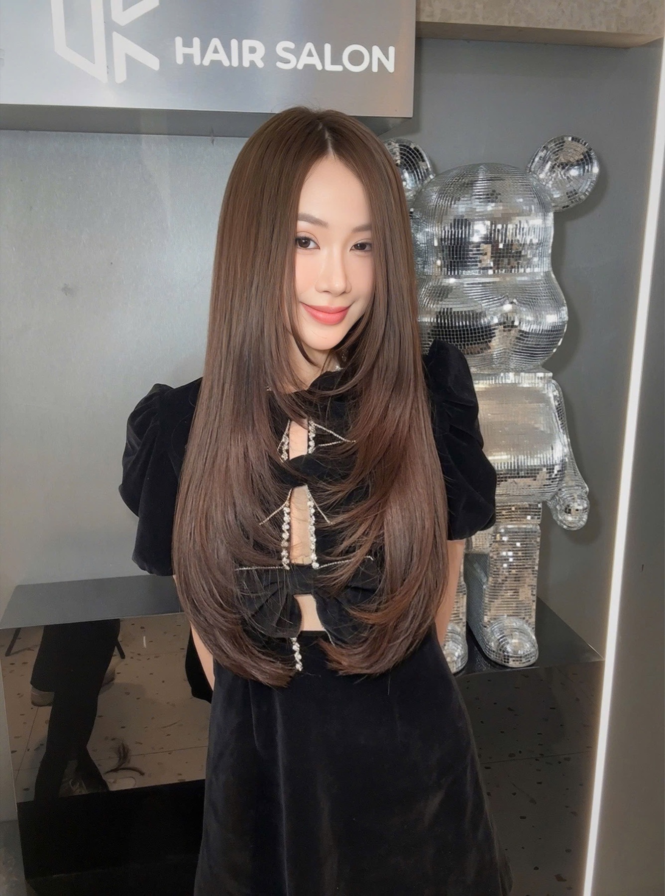 Khách hàng với mái tóc nâu layer dài bóng mượt tại UK Hair Salon
